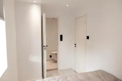 a white bathroom with a toilet and a door at Lille Luxury moderne feriehus med stor uteplass, utekjøkken og pergola in Bergen