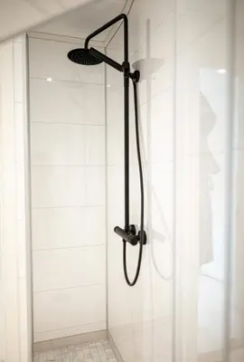 a shower with a glass door in a bathroom at Lille Luxury moderne feriehus med stor uteplass, utekjøkken og pergola in Bergen