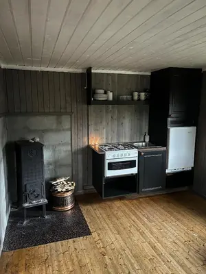 a kitchen with a stove and a stove top oven at Koselig hytte på hugastølen in Vang I Valdres