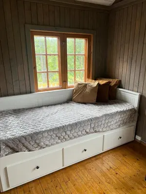 a large bed in a room with a window at Koselig hytte på hugastølen in Vang I Valdres