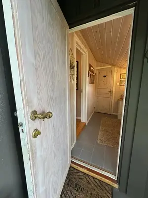 an open door to a hallway with a tile floor at Koselig hytte i sjøkanten in Ålesund