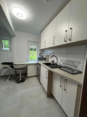 a kitchen with white cabinets and a table at Cozy apartment in Tennfjord in Tennfjord
