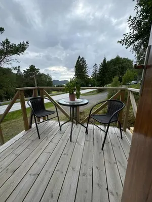 a patio with two chairs and a table on a deck at Cozy apartment in Tennfjord in Tennfjord