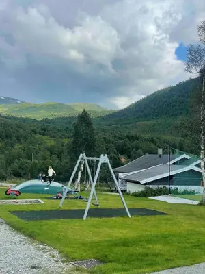 a man is on a swing set in a park at Familiy apartment in Myrkdalen Voss in Vossestrand