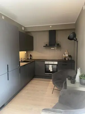 a kitchen with black cabinets and a table in a room at Familiy apartment in Myrkdalen Voss in Vossestrand