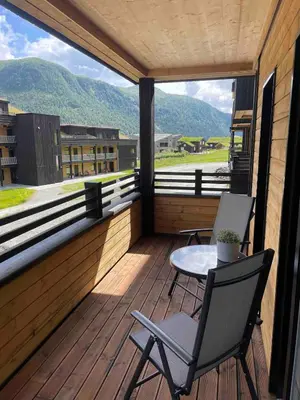 a balcony with two chairs and a table on it at Familiy apartment in Myrkdalen Voss in Vossestrand