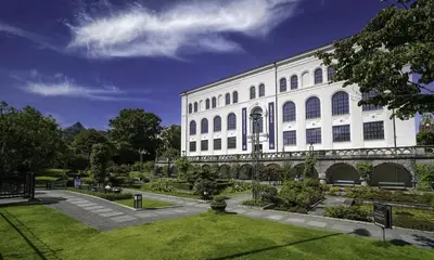 a white building with a garden in front of it at Central apt in the centre of Bergen in Bergen
