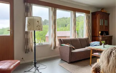 a living room with a couch and a chair and windows at 7 Bedroom Amazing Home In Nedre Vats in Stokka