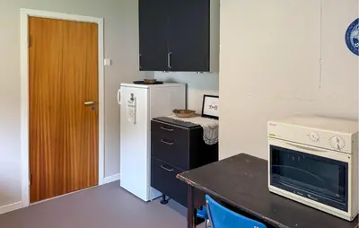 a small kitchen with a refrigerator and a table at 7 Bedroom Amazing Home In Nedre Vats in Stokka
