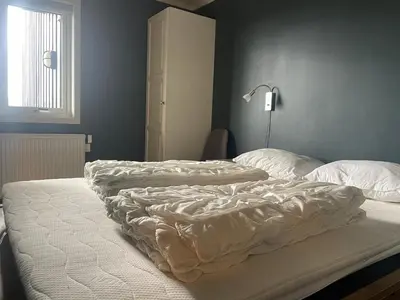 two unmade beds in a bedroom next to a window at Central, Cozy & Pet-Friendly in Beitostøl