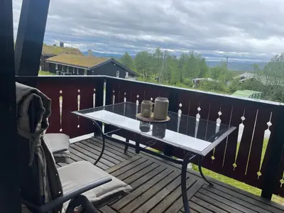 a balcony with a table and chairs on a deck at Central, Cozy & Pet-Friendly in Beitostøl