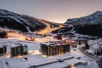 a view of a resort in the snow at night at Penthouse with large rooftop terrace, Ski In-Ski Out in Hemsedal in Hemsedal