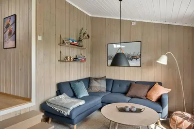 a living room with a blue couch and a table at Bitigrenda M in Beitostøl