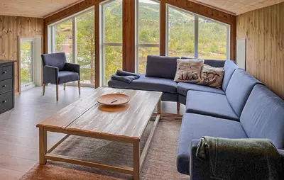 a living room with a blue couch and a table at Cozy Home In Hovden I Setesdal - With Jacuzzi in Hovden