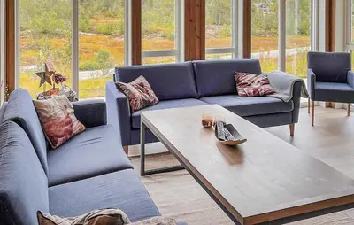 a living room with blue couches and a coffee table at Cozy Home In Hovden I Setesdal - With Jacuzzi in Hovden