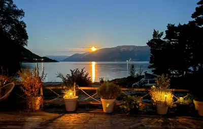 a sunset over a lake with some potted plants at 2 Bedroom Stunning Home In Lavik in Lavik