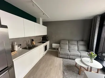 a kitchen and living room with a couch and a table at Cozy little apartment in Ålesund in Ålesund
