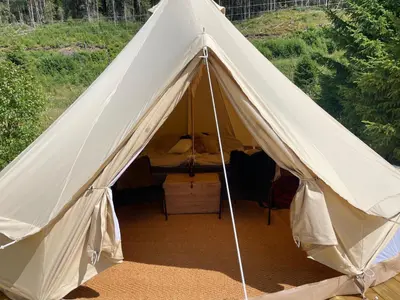 a white tent with a bed in it at River Glamping - Jordet, Trysil in Trysil