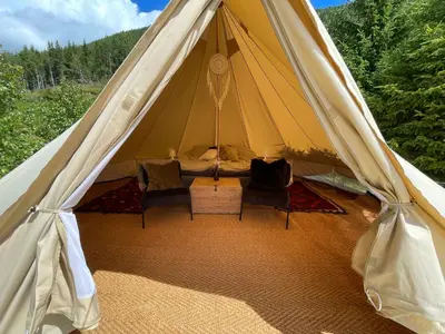 a tent with chairs and a bed in it at River Glamping - Jordet, Trysil in Trysil