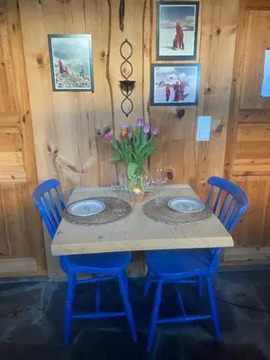 a table with blue chairs and a vase of flowers on it at Cabin in Oppstryn in Stryn