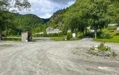 a dirt road with a building on the side of a mountain at 2 Bedroom Awesome Home In Lavik in Lavik