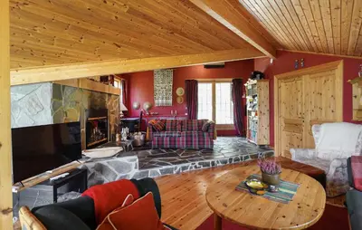 a living room with a fireplace and a table at Awesome Home In Uvdal With Sauna in Uvdal
