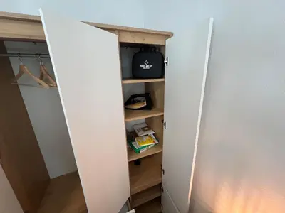 a closet with a white door and shelves at Cozy Gem in the Heart Of Bergen in Bergen