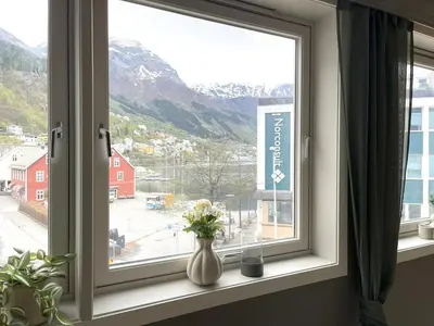a window with a vase of flowers on a window sill at Nyrenovert leilighet med 3 soverom i Odda sentrum in Odda