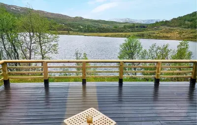 a bench on a boardwalk next to a lake at Amazing Home In Hemsedal With Wifi in Hemsedal