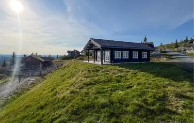 a small house on top of a grassy hill at Cozy Home In Sjusjøen With Wifi in Sjusjøen