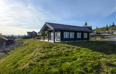 a small house on top of a grassy hill at Cozy Home In Sjusjøen With Wifi in Sjusjøen