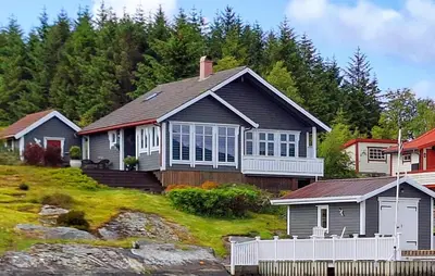 a house on top of a hill with houses at Cozy Home In Florø With Wifi in Florø