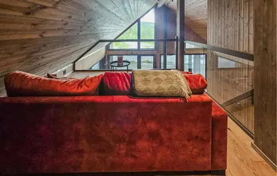 a red couch with pillows sitting in a room with stairs at Stunning Home In Nesbyen With Wifi in Nesbyen