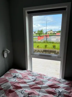 a bedroom with a bed and a large window at Luksuriøs enebolig, nær Ålesund in Ytterland