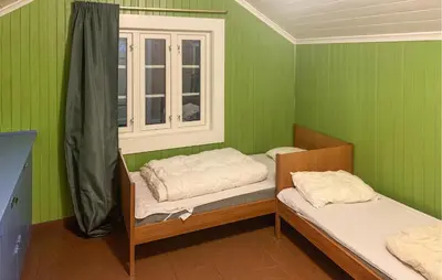 a green room with two bunk beds and a window at 2 Bedroom Awesome Home In Dovre in Dovre