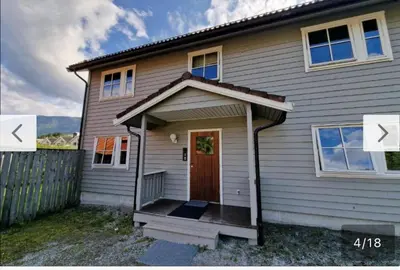 a white house with a door and a fence at Rom i bofelleskap in Sogndal
