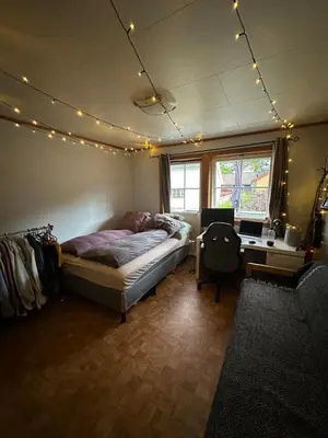 a bedroom with a bed and a desk and lights at Rom i bofelleskap in Sogndal