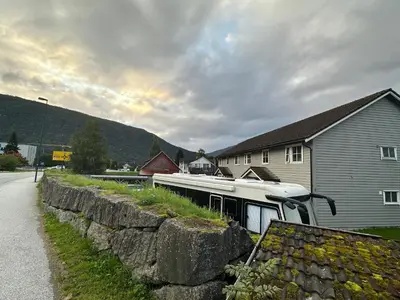 a boat is parked next to a stone wall at Rom i bofelleskap in Sogndal