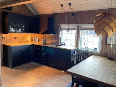 a kitchen with blue cabinets and a table with chairs at Hovden Fjellpark 71 in Hovden