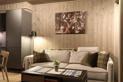 a living room with a couch and a painting of a deer at Stylish apartment in Hemsedal, Ski in-ski out in Hemsedal