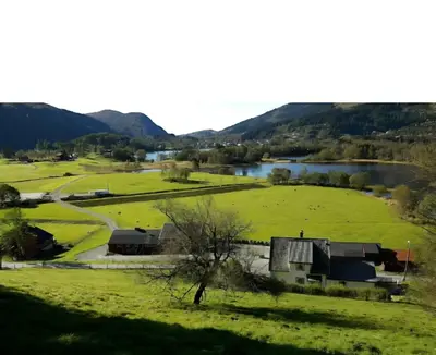 a view of a farm with a river and mountains at Nesvika nature reserve Apartment only 20 min away from Bergen in Bergen