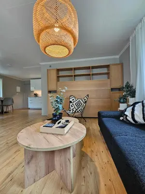 a living room with a blue couch and a table at Nesvika nature reserve Apartment only 20 min away from Bergen in Bergen