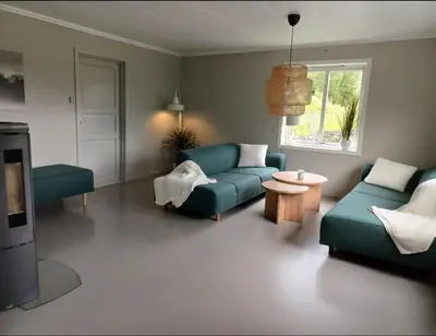 a living room with two blue couches and a table at Nesvika 5 bedroom holiday home, only 25 min from Bergen in Bergen