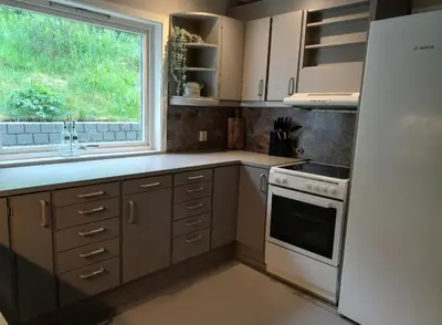 a kitchen with a white refrigerator and a window at Nesvika 5 bedroom holiday home, only 25 min from Bergen in Bergen