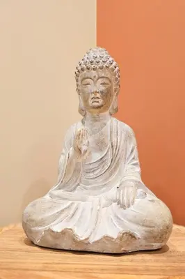 a white statue of a buddha sitting on a table at Helgøya Hideaway
