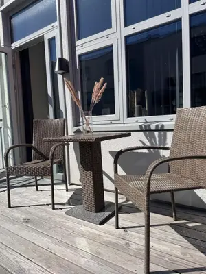 a table and two chairs and a lamp on a porch at ingen in Bergen