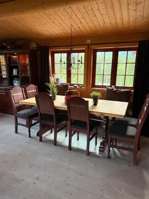 a dining room with a wooden table and chairs at Spacious mountain cabin in Valdres with 3 bedrooms in Vevle