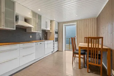 a kitchen with white cabinets and a table and chairs at The Oak Courtyard