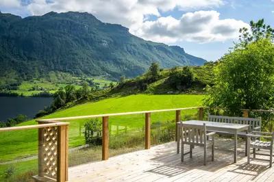 a deck with a table and chairs and a view of a mountain at The Oak Courtyard