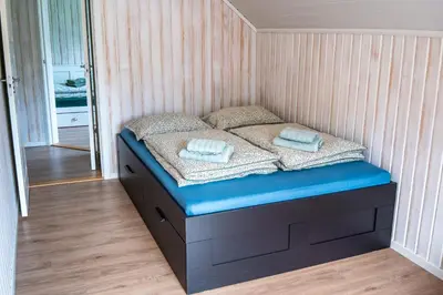 a small bed in a small room with blue sheets and pillows at The Oak Courtyard